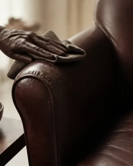 Comment nettoyer fauteuil cuir : main essuie l’assise en cuir avec microfibre humide