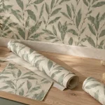 Tendance papier peint pour cuisine : motif botanique beige lin et vert céladon sur mur de cuisine
